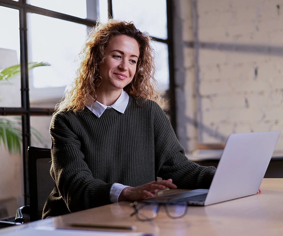 Mulher no computador representando a automação da gestão da dívida líquida nas empresas