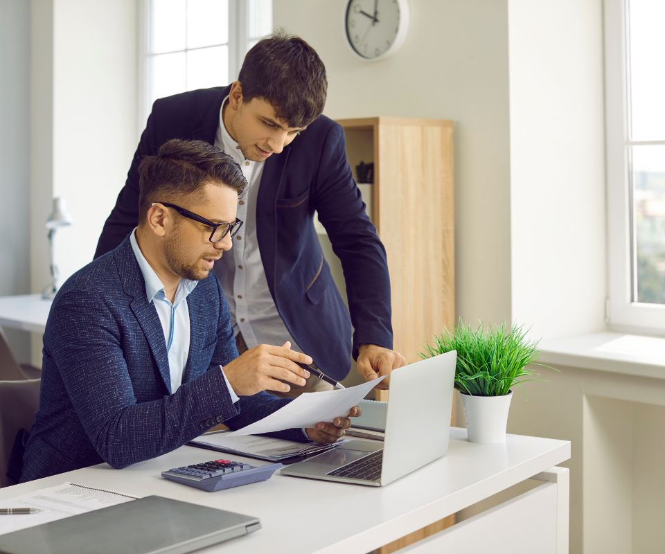 Duas pessoas em um escritório financeiro trabalhando na integração de pagamentos via API entre sistemas